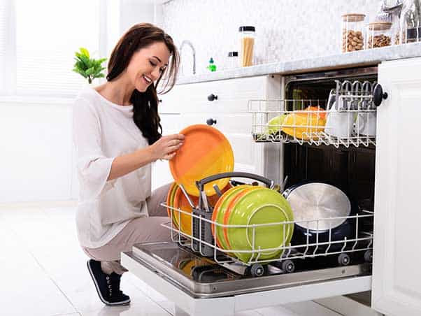 Picture of lady with clean dishes in her dishwasher