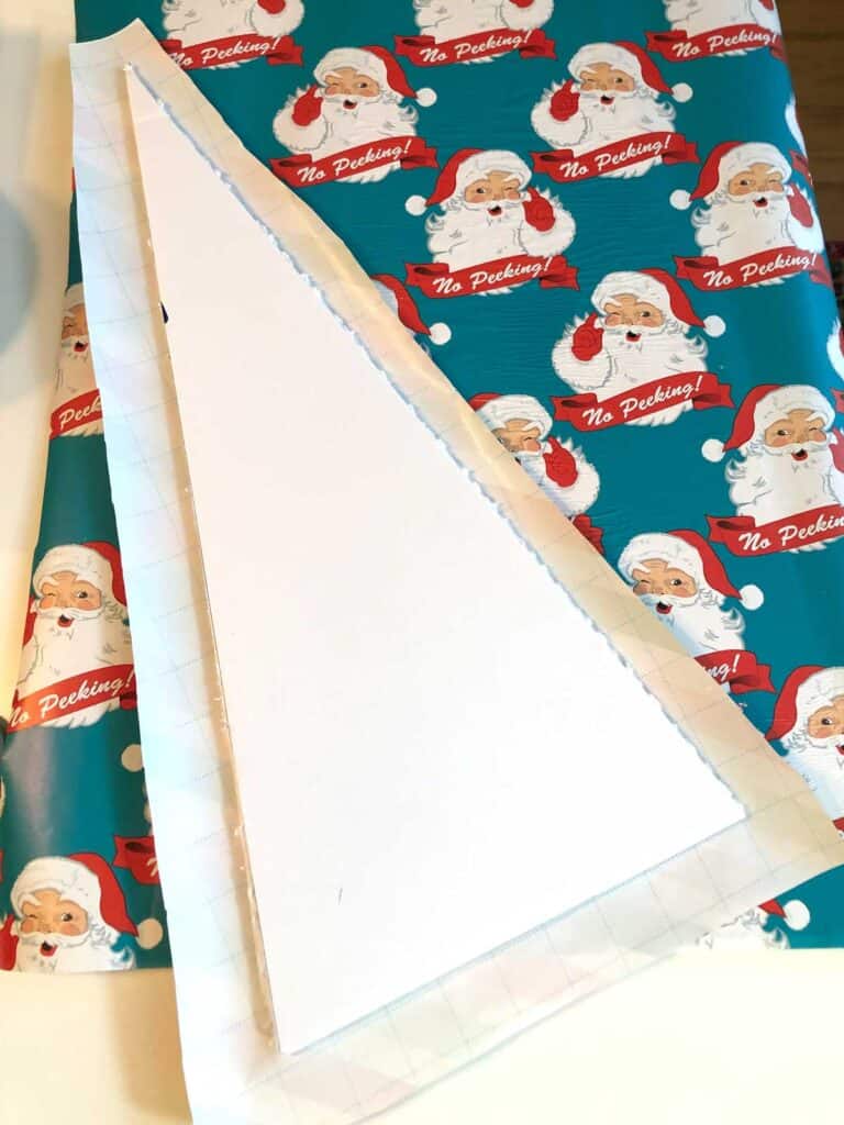 3. Use Glue To Stick The Paper On... Cover one side of the Christmas tree with glue (I used Mod Podge) and then press it onto the wrapping paper, smushing it down to make it stick. 