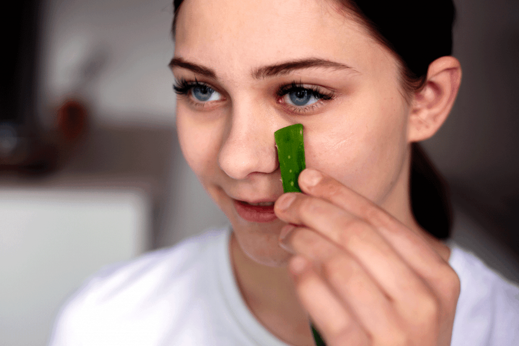 Woman holding aloe vera under eyes to reduce bags