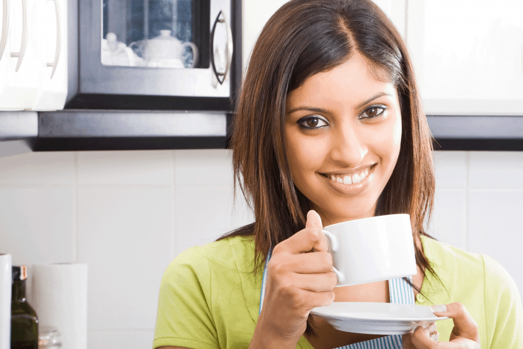 Woman drinking tea before she uses the tea bags to get rid of her undereye bags