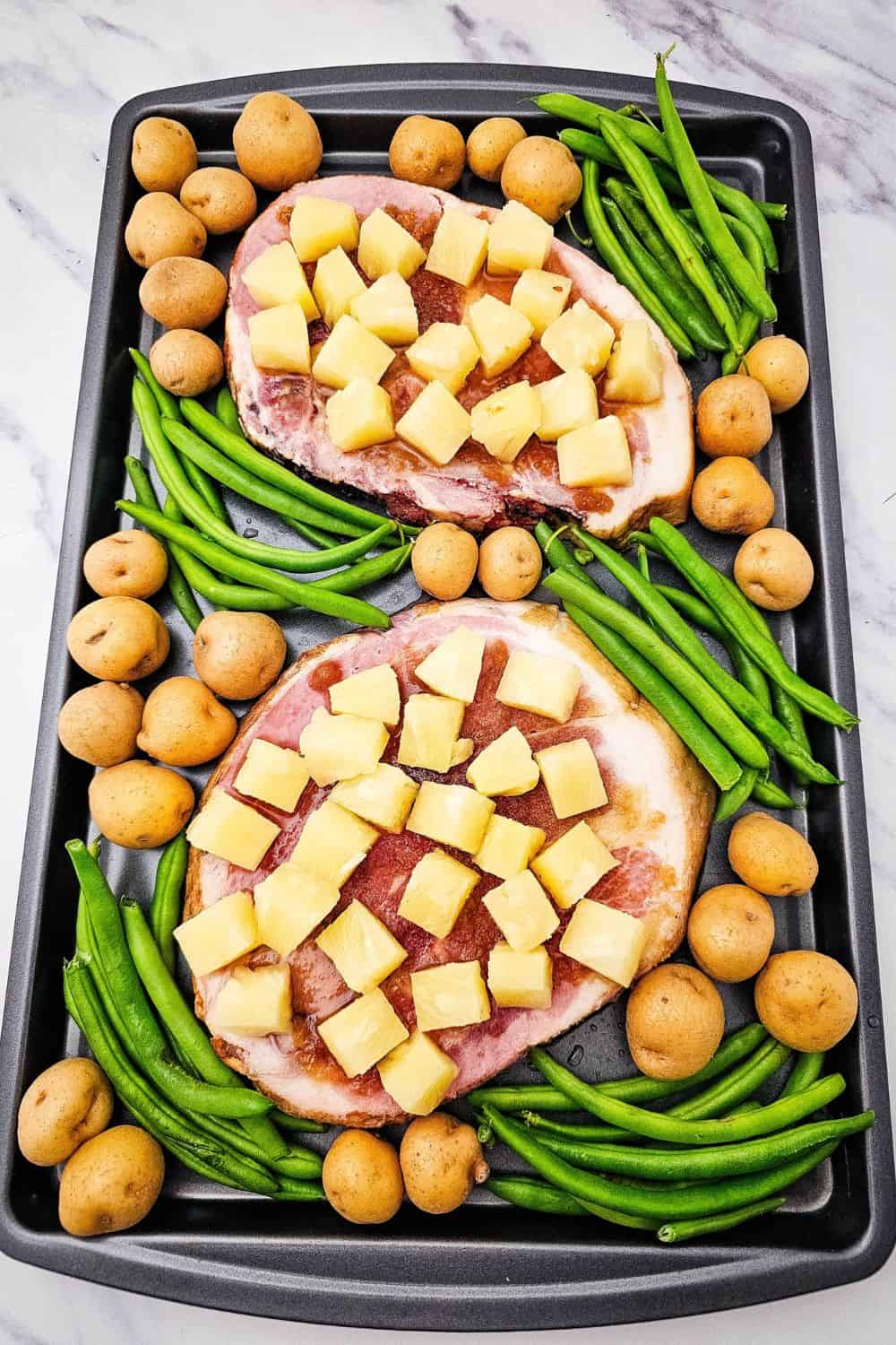 Looking for ham steak recipes baked in oven that actually taste like something? Press brown sugar into thick ham steaks, pile on pineapple chunks, and roast at 400 degrees with baby potatoes and green beans. The ham caramelizes, the potatoes get golden, and dinner is on the table in 35 minutes. An easy ham steak dinner, a one sheet pan meal, and a cozy family dinner idea all in one. Pin this to try this week!