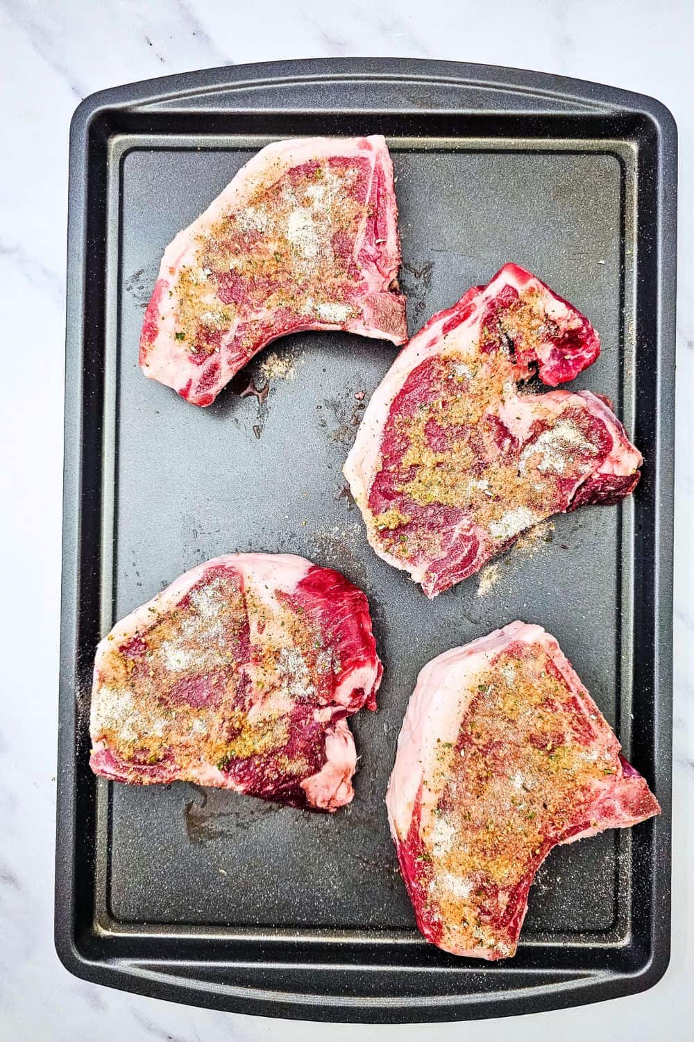 These sheet pan ranch pork chops and potatoes are the easy one pan dinner you need on a busy weeknight. Juicy pork chops and tender baby potatoes get tossed in ranch seasoning, paprika and oregano, then roasted together in the oven for a hearty, comforting meal with barely any cleanup. A simple pork chop sheet pan dinner that serves four. Save this easy pork chop recipe for your next family dinner!